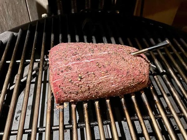 Rosbief op een barbecue rooster met een thermometer er in